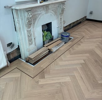 An oak herringbone floor with a double border and inlay