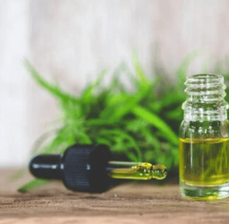 a bottle of oil with a plant in the background
