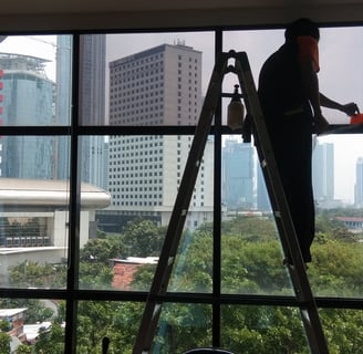 a man is standing on a ladder to get a picture of a window