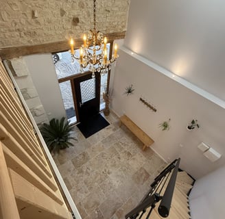 a staircase leading to a foyer with a chandelier