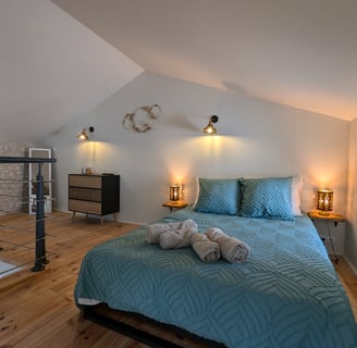 a bed with a blue bedding and a glass table