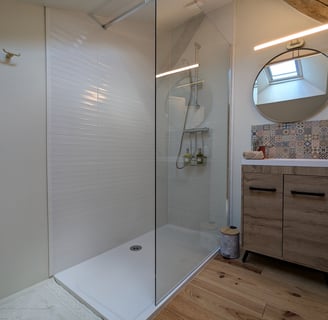 a bathroom with a shower and a wooden vanity