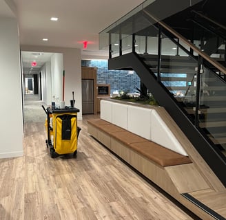 A janitor's cart inside the kitchen area of an office building.