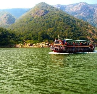 A boat with passengers travelling in mid of mountains