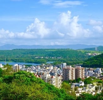 A city view with trees and mountains surrounding with blue sky