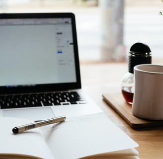 a laptop computer and a pen on a desk