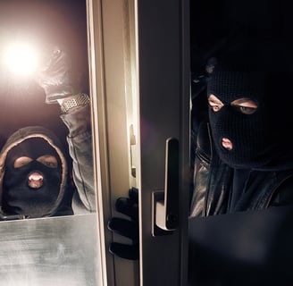 two burglars breaking into a residential homes unlocked window