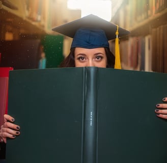 graduate peering over book