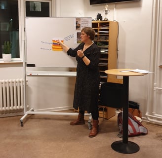 Billede af Gunda som holder oplæg og forklarer noget på en tavle.