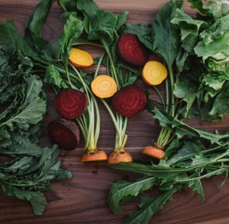 Un assortimento di verdure fresche sicure per i conigli disposte su un tavolo accanto a un coniglio 