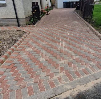 a driveway with a brick paved driveway and a driveway