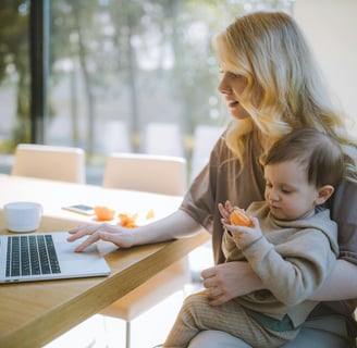 a woman sitting at a table with a baby in her lap