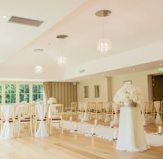 a wedding ceremony with white flowers and white chairs