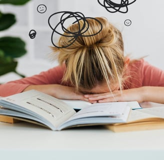 a woman with her head in her hands, with a book and a book on