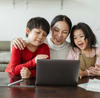 a woman and two children sitting at a table