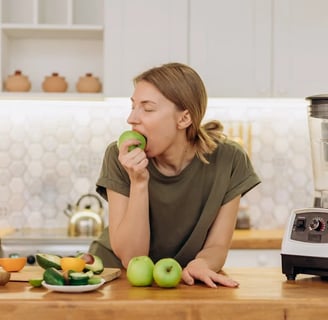 a woman is eating a green apple in a blender