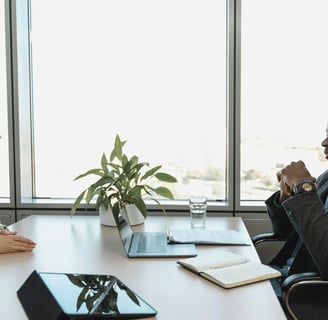 a man and woman sitting at a table with a laptop