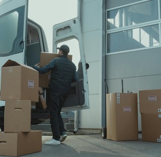 a man is moving boxes into a van