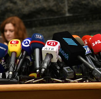 a woman standing at a podium with microphones and microphones