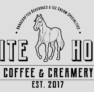 A logo with a white horse that says White Horse Cofee & Creamery
