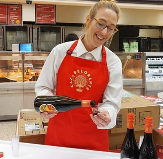 A woman in a red apron and a red apron. Morrisons Launches In-Store Sampling to Enhance Customer Exp