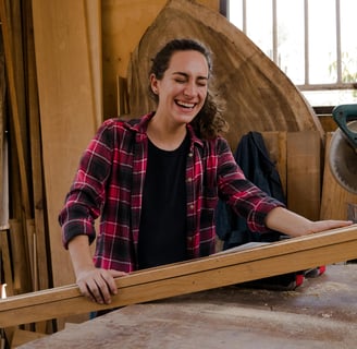 a woman in a plaid shirt in a woodwork shop