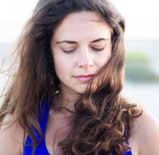 a woman in a blue dress is looking down at her cell phone