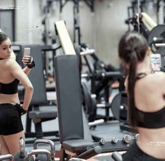 Joven en gimnasio tomándose selfies, reflejo del problema del fitness sin propósito