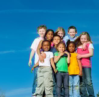 A colorful group of children standing on a hilltop