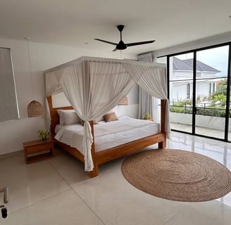 Cozy bed facing tropical greenery in a modern Balinese villa