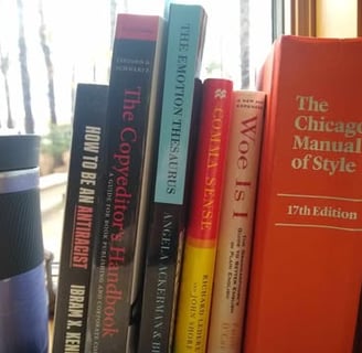 A windowsill holding several books and a coffee cup