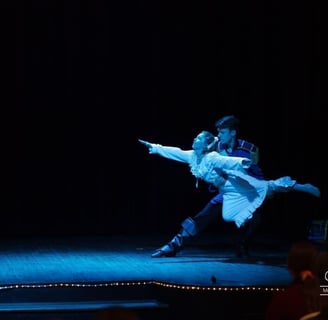 a boy and girl dancing on stage in a show of the Nutcracker.
