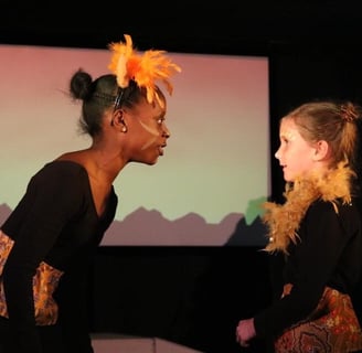 two kids in costumes standing in front of a screen