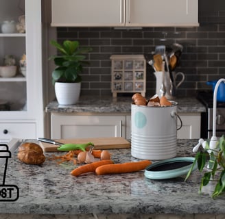 Kitchen compost bin on a countertop with vegetable peels, eggshells, and food scraps, composting