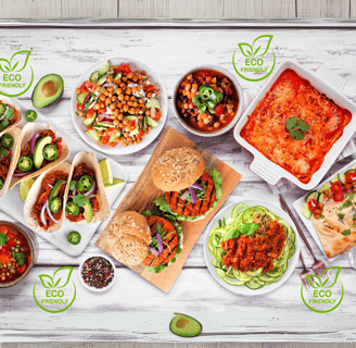 A colorful spread of plant-based dishes, including tacos, veggie burgers, salads, lentil soup