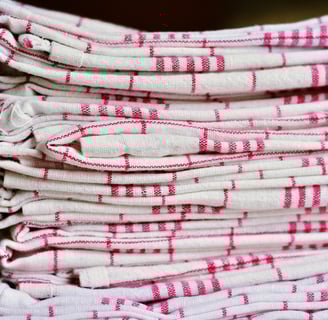 Stack of folded cloth napkins in checkered patterns, eco-friendly alternatives to paper napkins