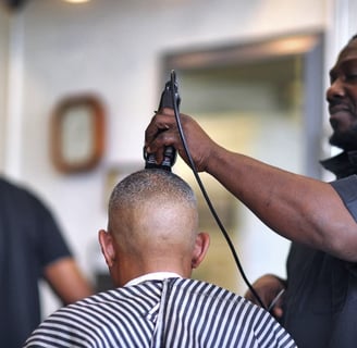 a man is getting his hair cut by a barber