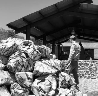 a man standing in front of a pile of bags