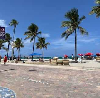 a beach with palm trees and people walking on the beach
