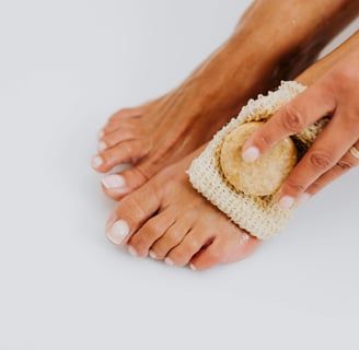 a person's feet with a scrub cloth on it showing nails and skin