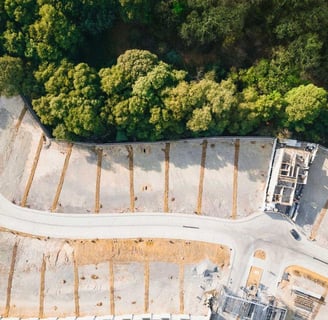 Vista aérea de una privada de lotes residenciales en Bosque Real, rodeada de naturaleza
