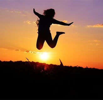 sunset background, silhouette human figure jumping for joy