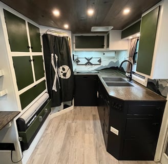 kitchen layout inside and expedition rig featuring fridge, freezer, sink, induction cooktop