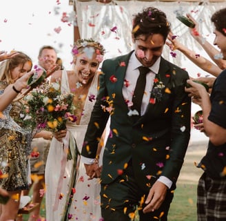 Flowers being thrown on bride and groom as they walk down the aisle