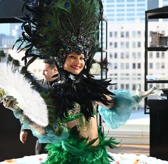 a woman in a green dress with feathers on a table