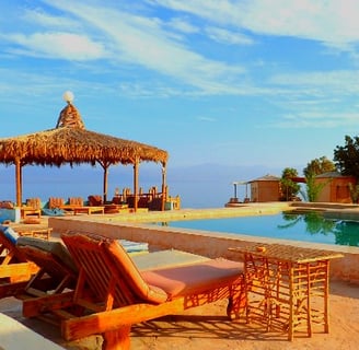 a beach resort with lounge chairs and umbrellas