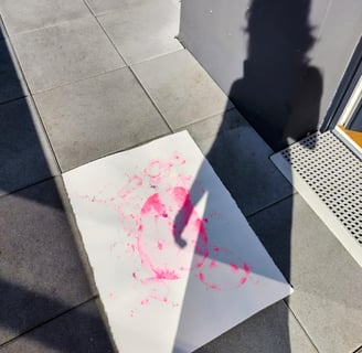 photo de l'ombre de l'artiste sur son œuvre à l'aquarelle rose