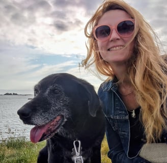 photo de l'artiste Eva Girardeau en bord de mer avec sa chienne Loula