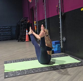 Eva guiding a private yoga session indoors in boat pose (Navasana)
