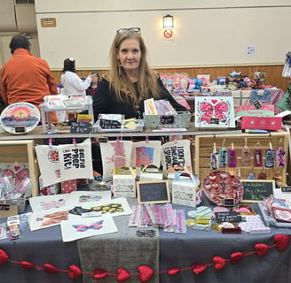 a woman standing behind a table with a table with a table cloth